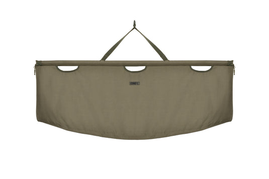 An olive-colored Korda Compac Weigh Sling for fishing, with a hanging loop, quick-release zips, and grab handles.