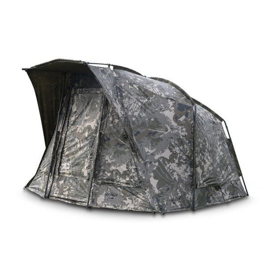 Nash Titan T1 Camo Pro. A camouflage bivvy with an extended awning set up outdoors. Front / Side View