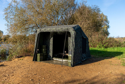 RidgeMonkey Green hunting blind set up outdoors with trees and grass in the background