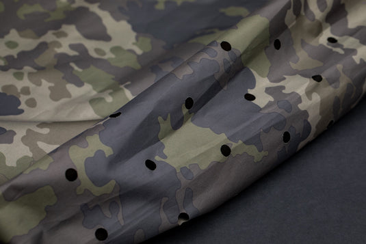 An olive-colored Korda Compac Weigh Sling for fishing, with a hanging loop, quick-release zips, and grab handles. Bottom drainage holes
