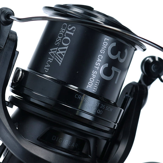 Close-up of a black fishing reel with branding on a white background