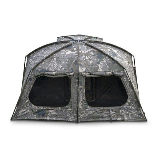 Nash Titan T1 Camo Pro. A camouflage bivvy with an extended awning set up outdoors. Back view, all windows open